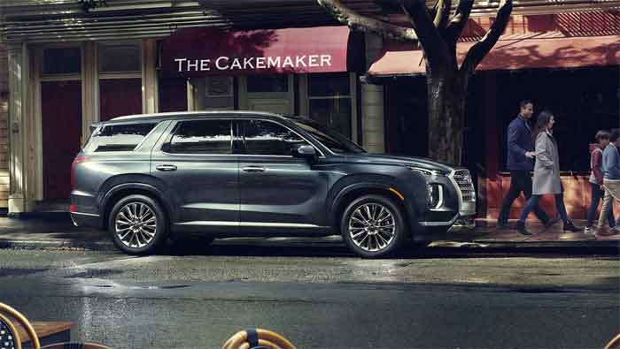 Large SUV parked on a city street outside a bakery, reflecting on a rainy day, featured on digipdemo.com.