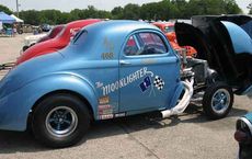 Vintage blue car at an auto show, showcasing engine modifications for alternative fuels, featured on digipdemo.com.