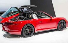 Red convertible car with roof retracting, showcased at an auto exhibit on digipdemo.com.