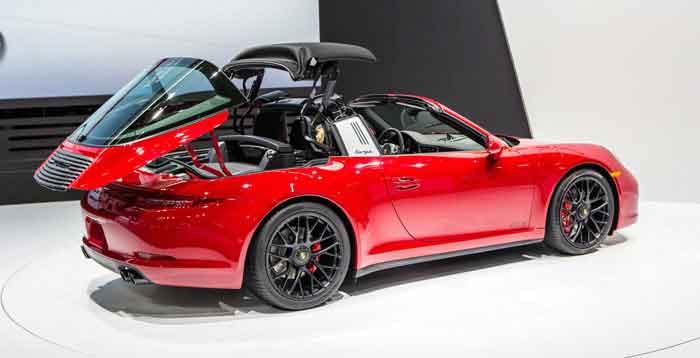 Red convertible car with roof retracting, showcased at an auto exhibit on digipdemo.com.