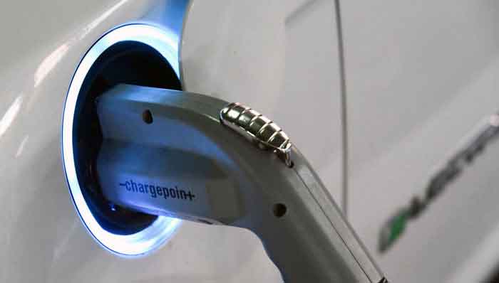 Electric car charger plugged into a vehicle, highlighting sustainable transportation on digipdemo.com.