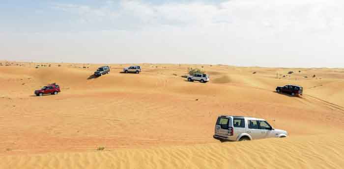 SUVs navigating sandy desert terrain, illustrating techniques on driving on sand for digipdemo.com article.