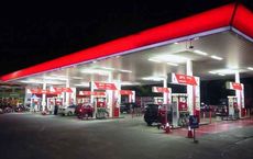"Nighttime view of a busy gas station, with multiple vehicles refueling, under bright lights on digipdemo.com."