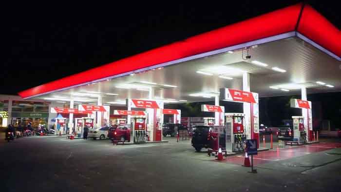 "Nighttime view of a busy gas station, with multiple vehicles refueling, under bright lights on digipdemo.com."